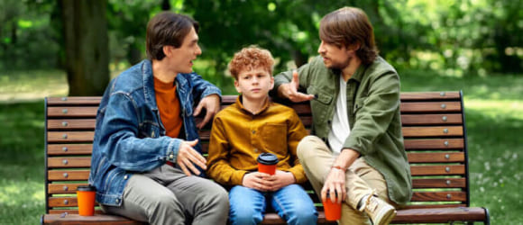 Segaduses poiss istub pargipingil kahe mehe vahel, kes räägivad investeerimisest